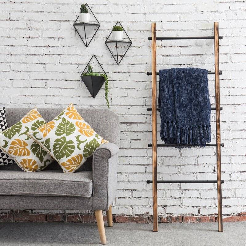 The wooden ladder provides enough storage space for your throws (from Wayfair)