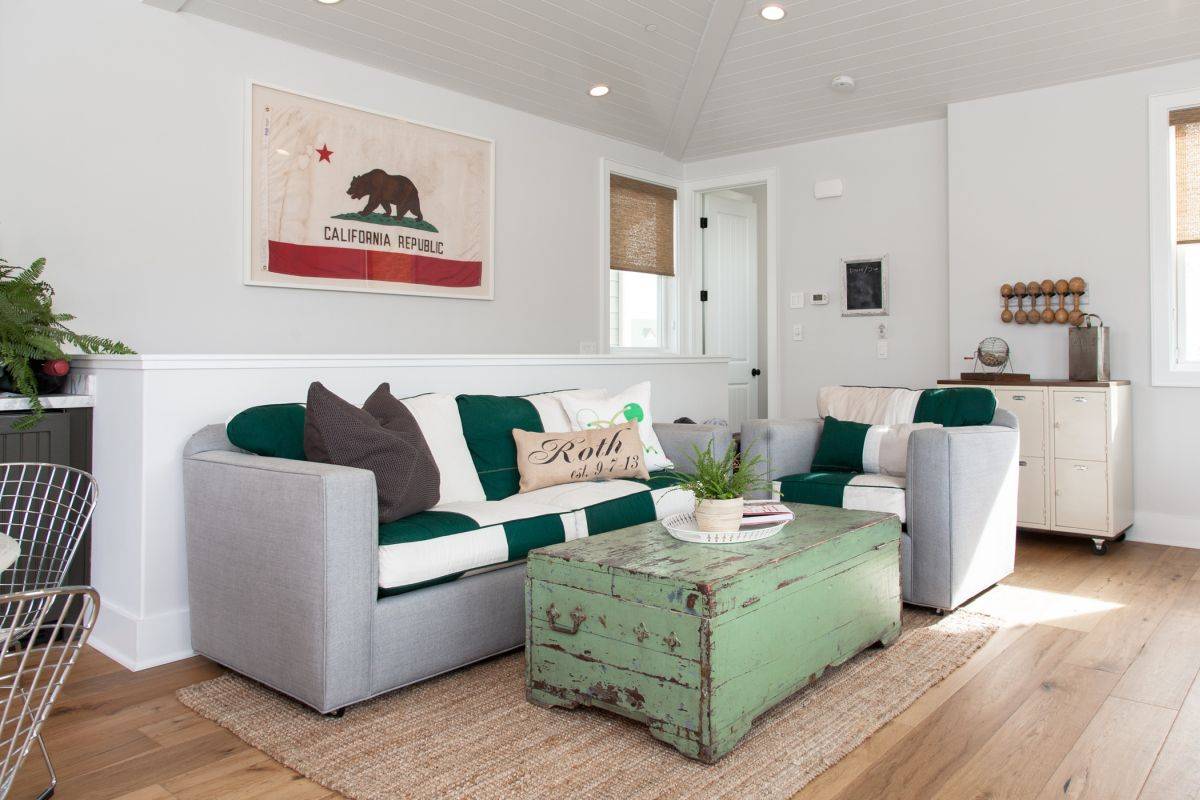 Both coffee table and accent pillows add a touch of green to this white living space