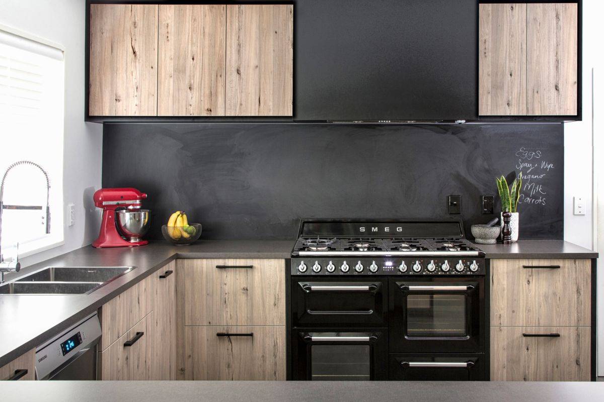 Chalkboard walls and appliances bring black to this wood and white kitchen