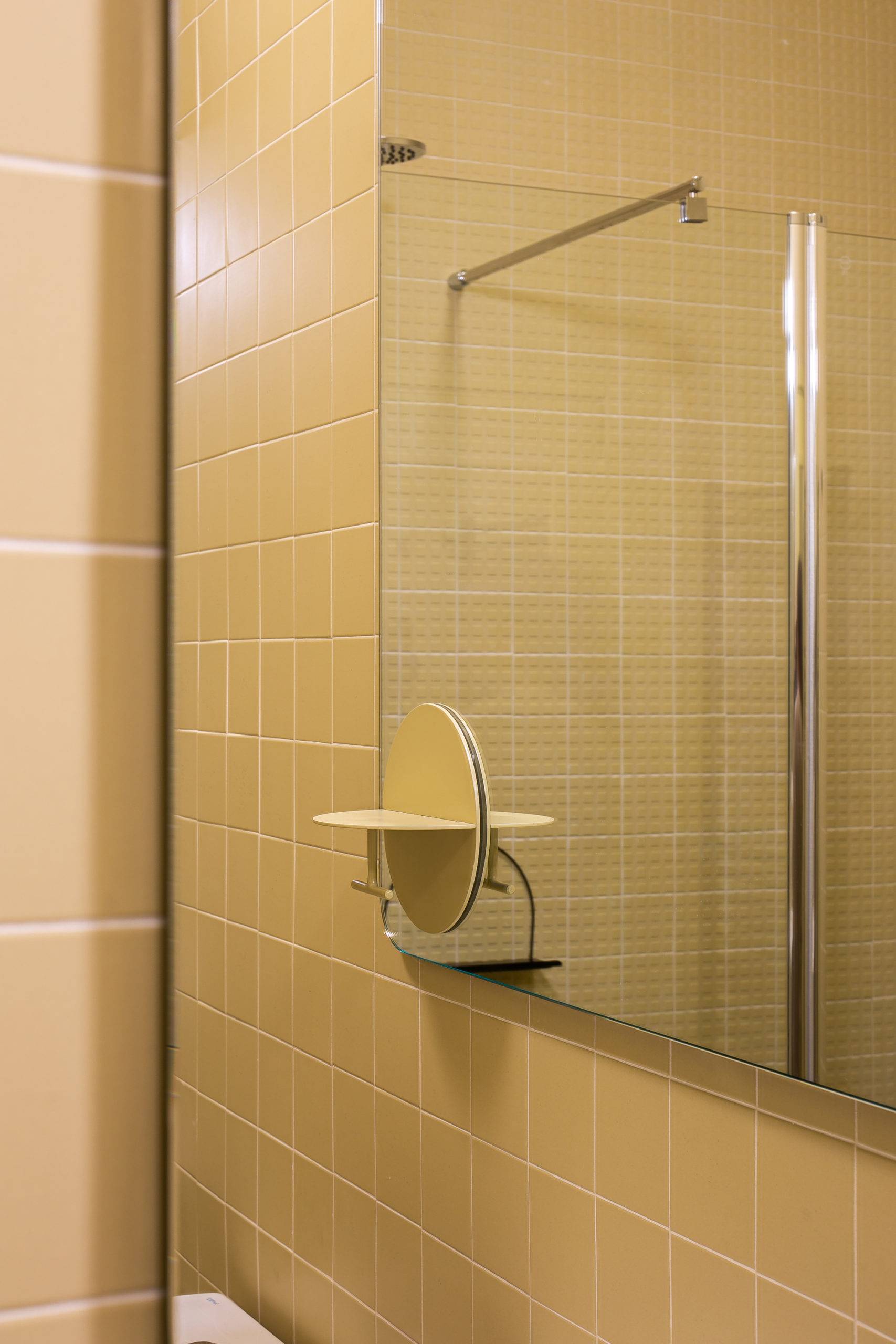 Closer look at the mirror and vanity inside the modern bathroom in light yellow