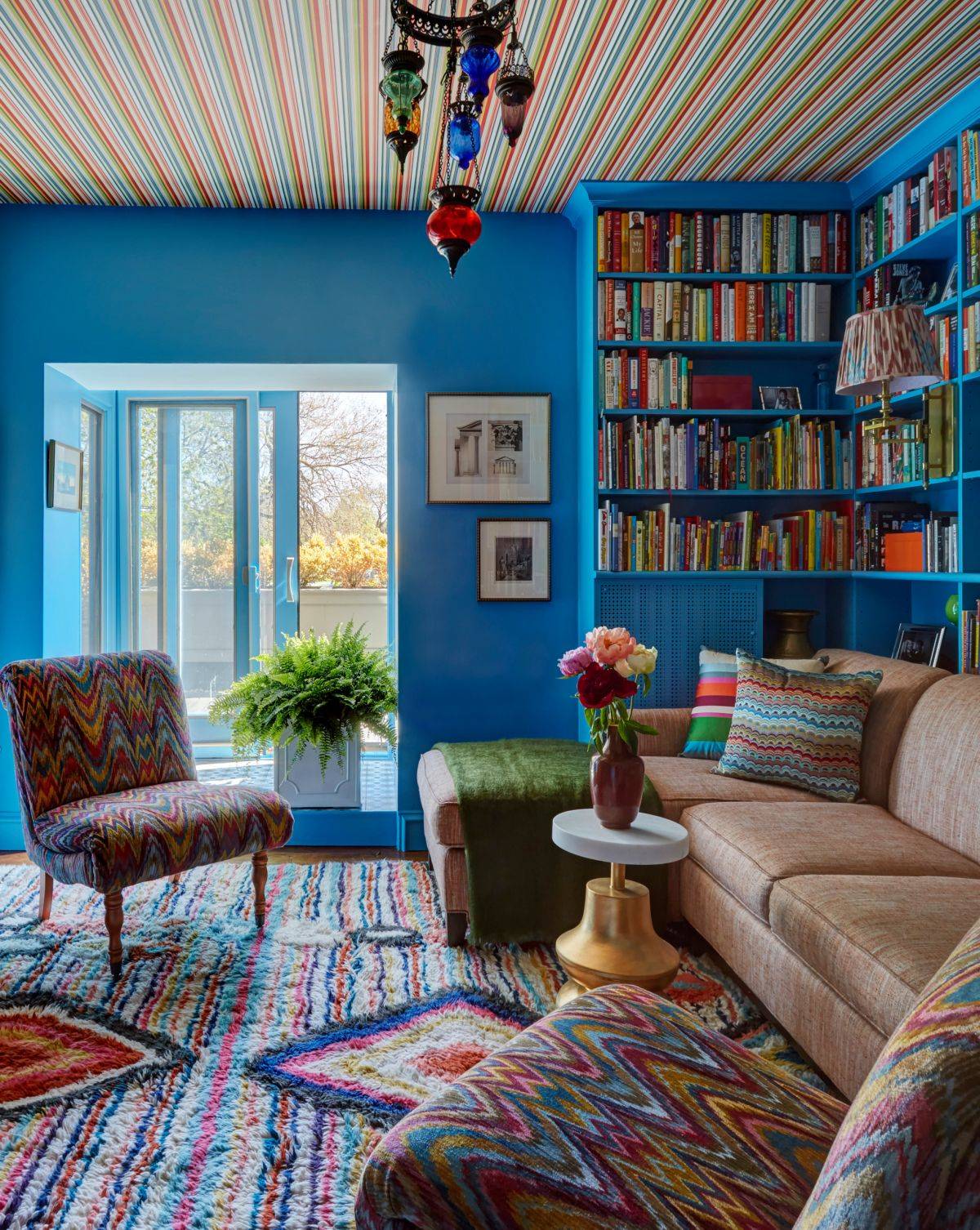 Colorful and fun home office with a large sitting area and ample shelf space