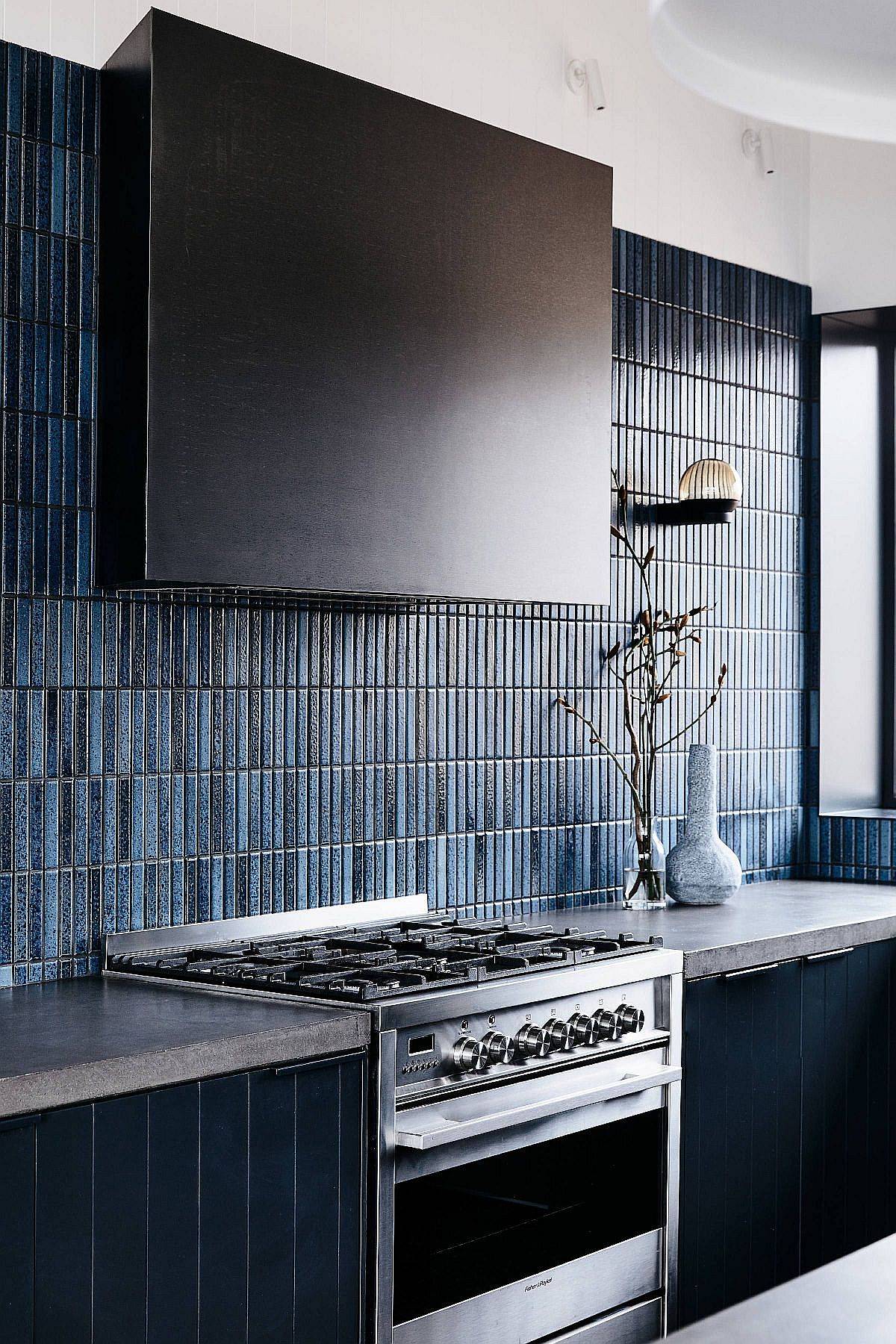 Different shades of blue brought in by the vertical tile backsplash make a big visual impact