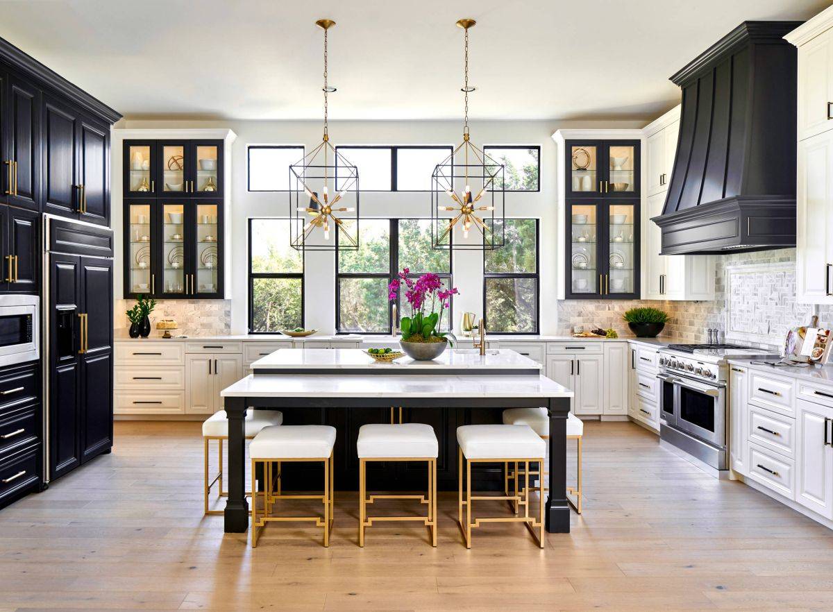 Faucets, bar stools and pendants bring warm metallic glow to this contemporary kitchen