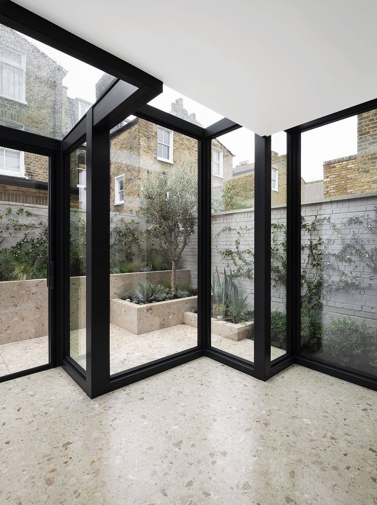 Glass boxes with metal frame extend the traditional home in a creative manner