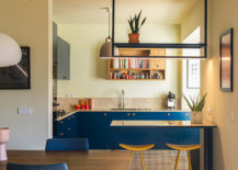 Kitchen-and-dining-area-of-the-apartment-with-ocean-blue-cabinets-and-yellow-bar-stools-35988-217x155