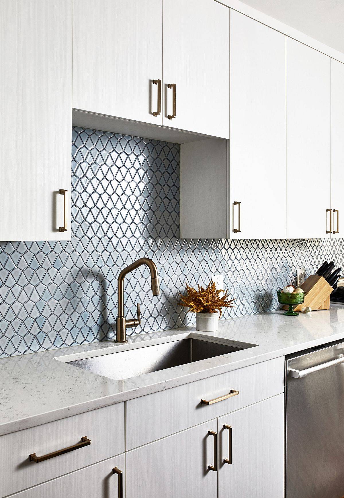 Kitchen in blue and white with stainless steel sink and quartz countertops