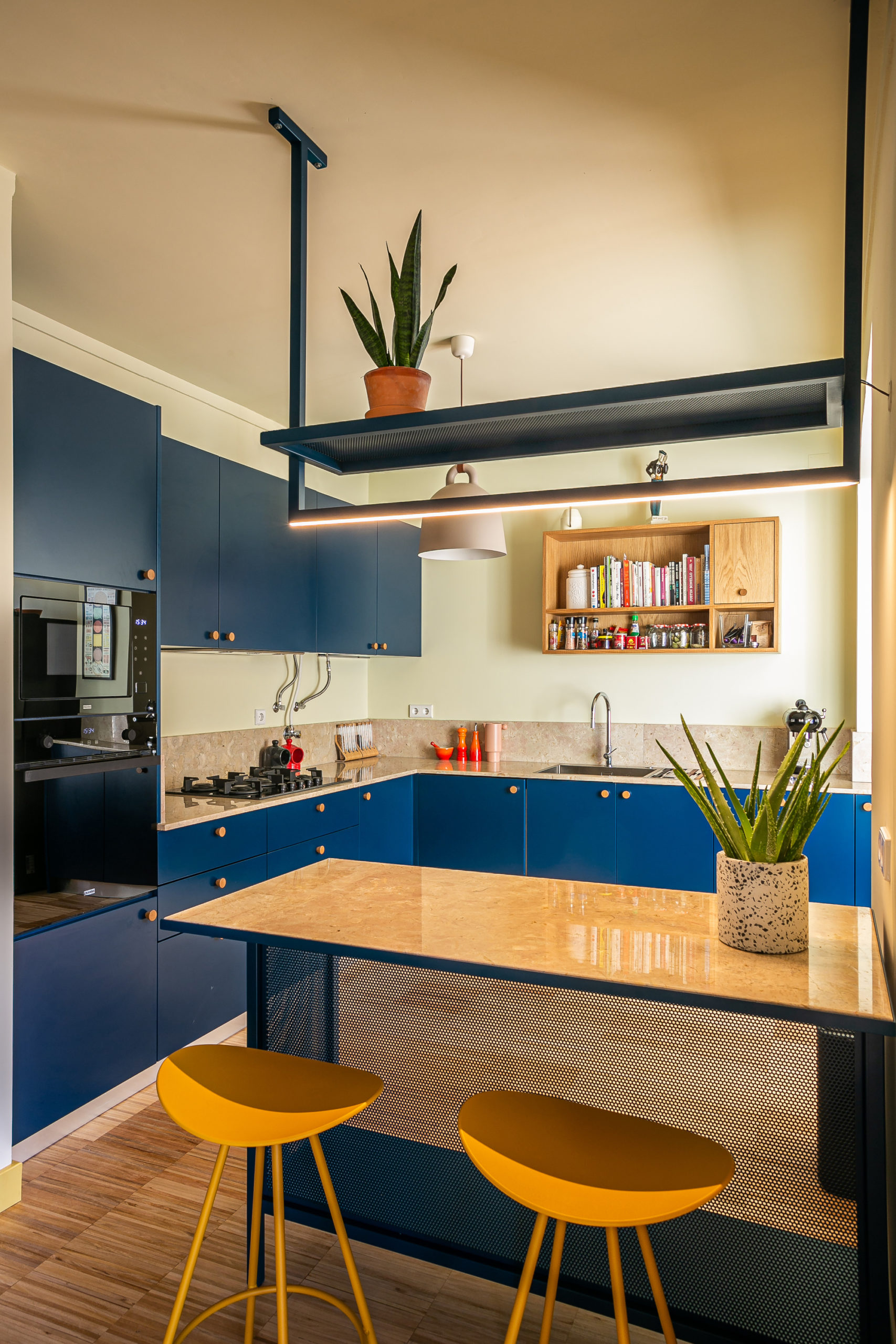 L-shaped modern kitchen with smart, space-savvy shelving and cabinets in blue