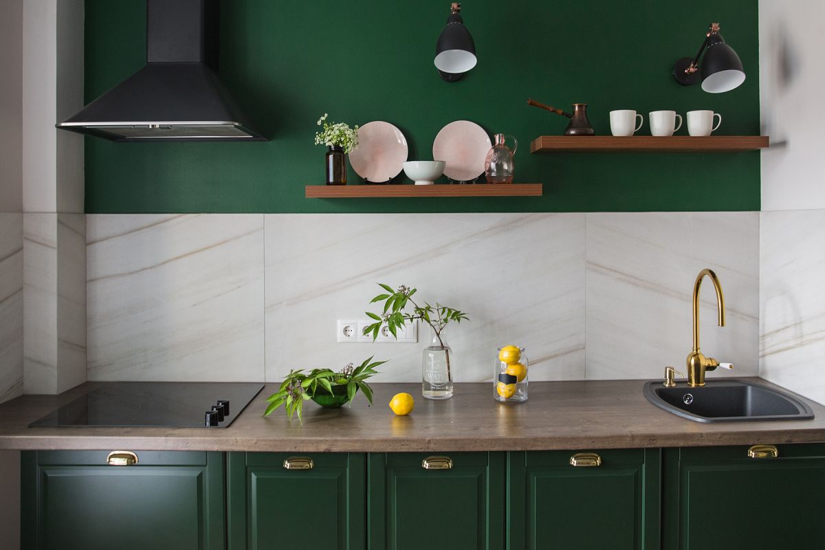 Small modern kitchen with dark green cabinets and a green background