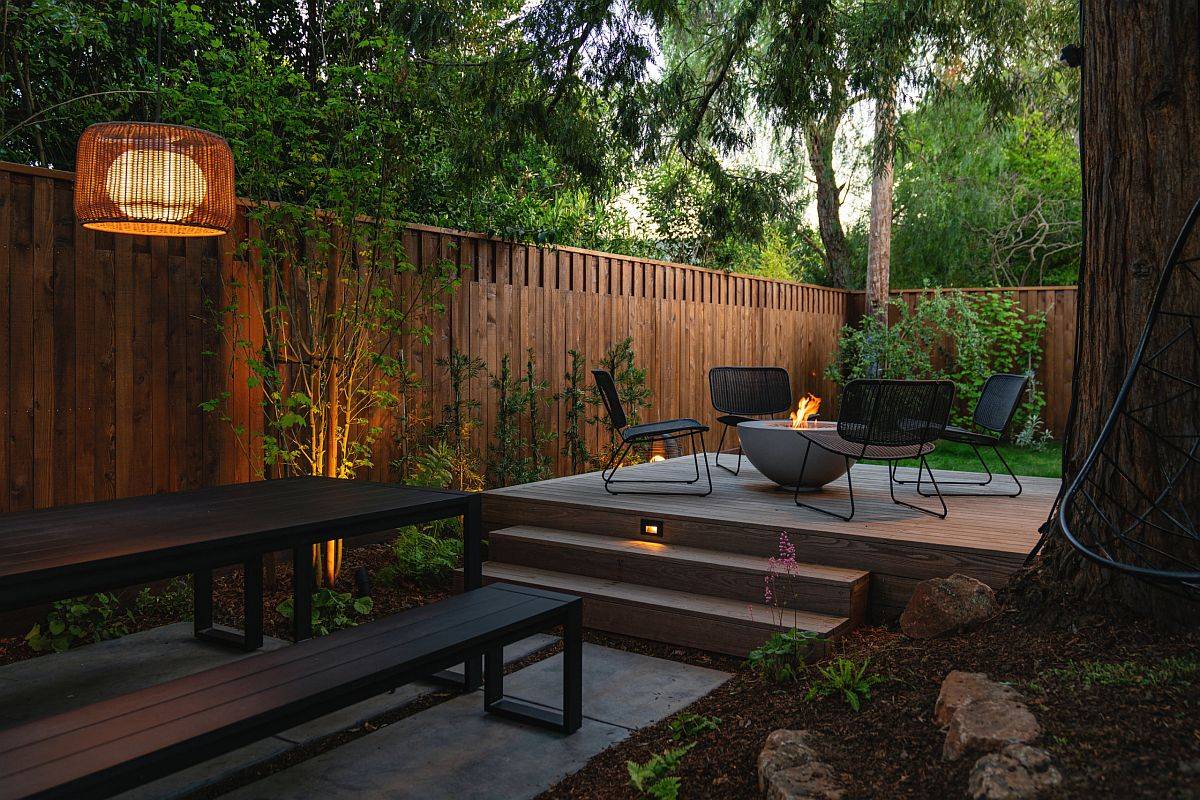 Small, private deck of urban home surrounded by greenery and a beautiful sitting area