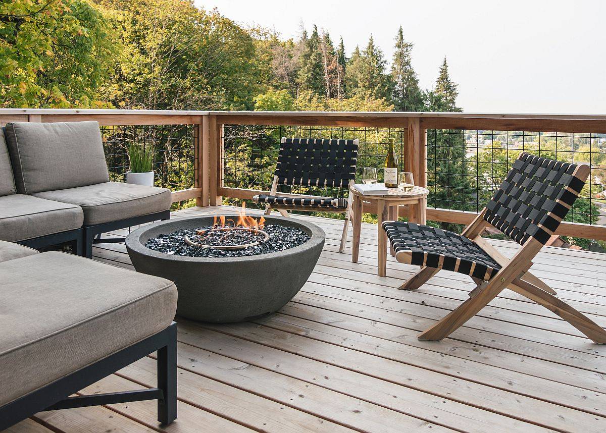 an image of a round concrete fire pit on a deck surrounded by outdoor furniture
