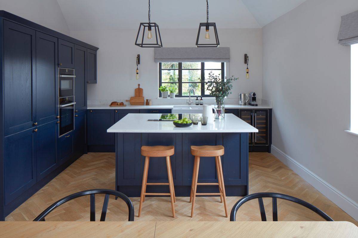 White, wood and deep blue modern kitchen with a practical island at its heart