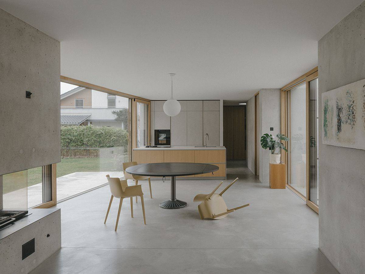 Wood and white open plan living in concrete with glass walls on two sides