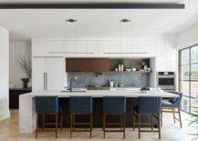 Bluish-gray-stone-backsplash-in-the-white-kitchen-with-bar-chairs-in-blue-76824-217x155