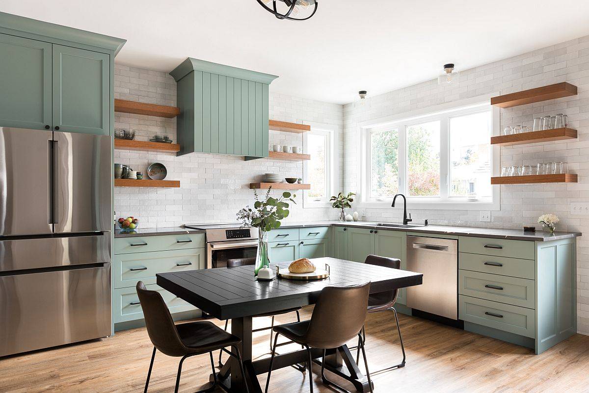 Kitchen with light green cabinets, white walls and sleek wooden floating shelves