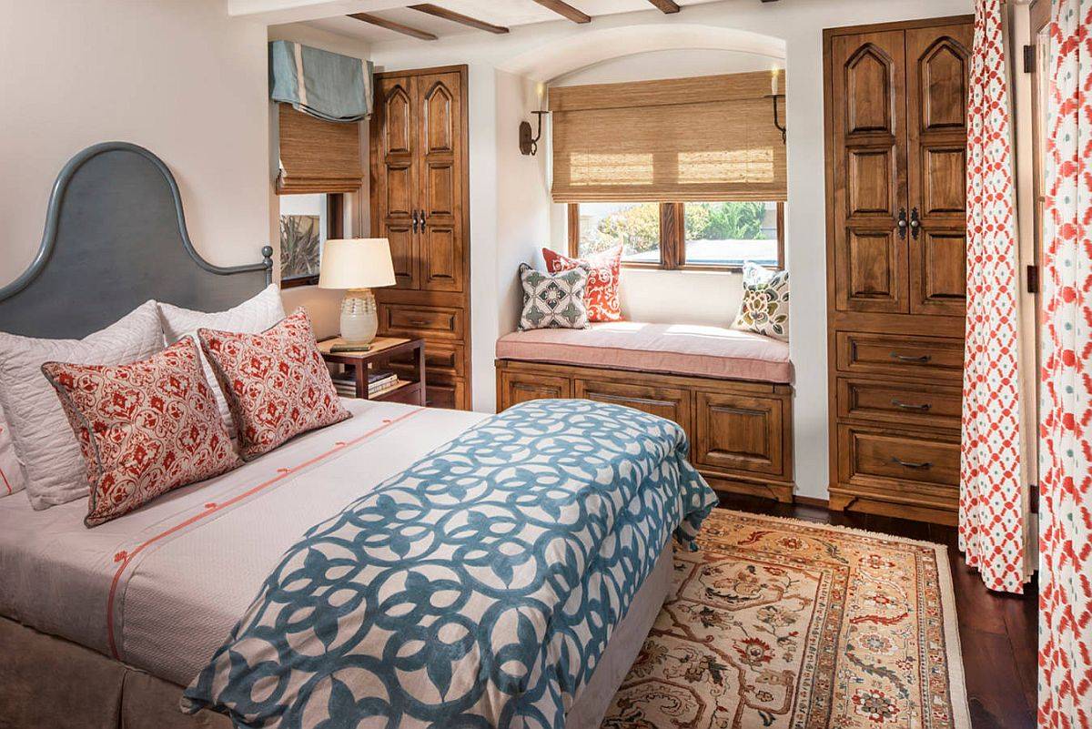 Modern Mediterranean style bedroom with a cozy window seat and storage that matches cabinets next to it