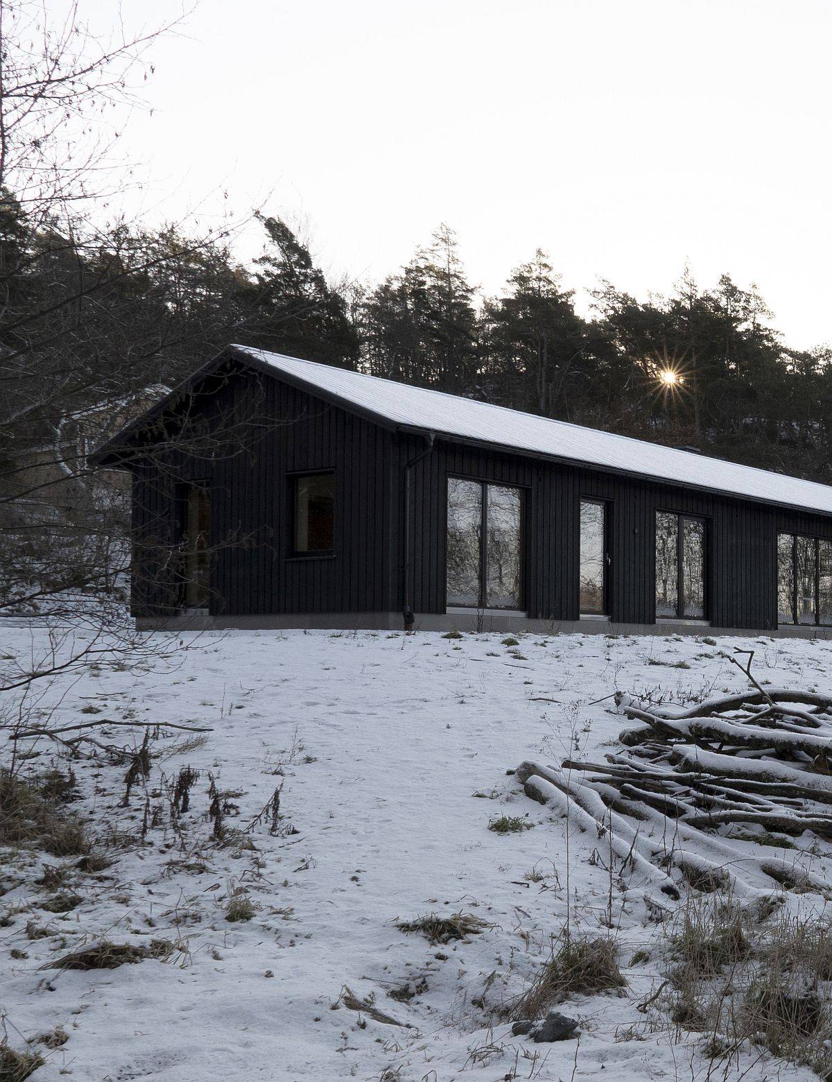 Black tar-treated wooden exterior of the lovely single-family home in Sweden