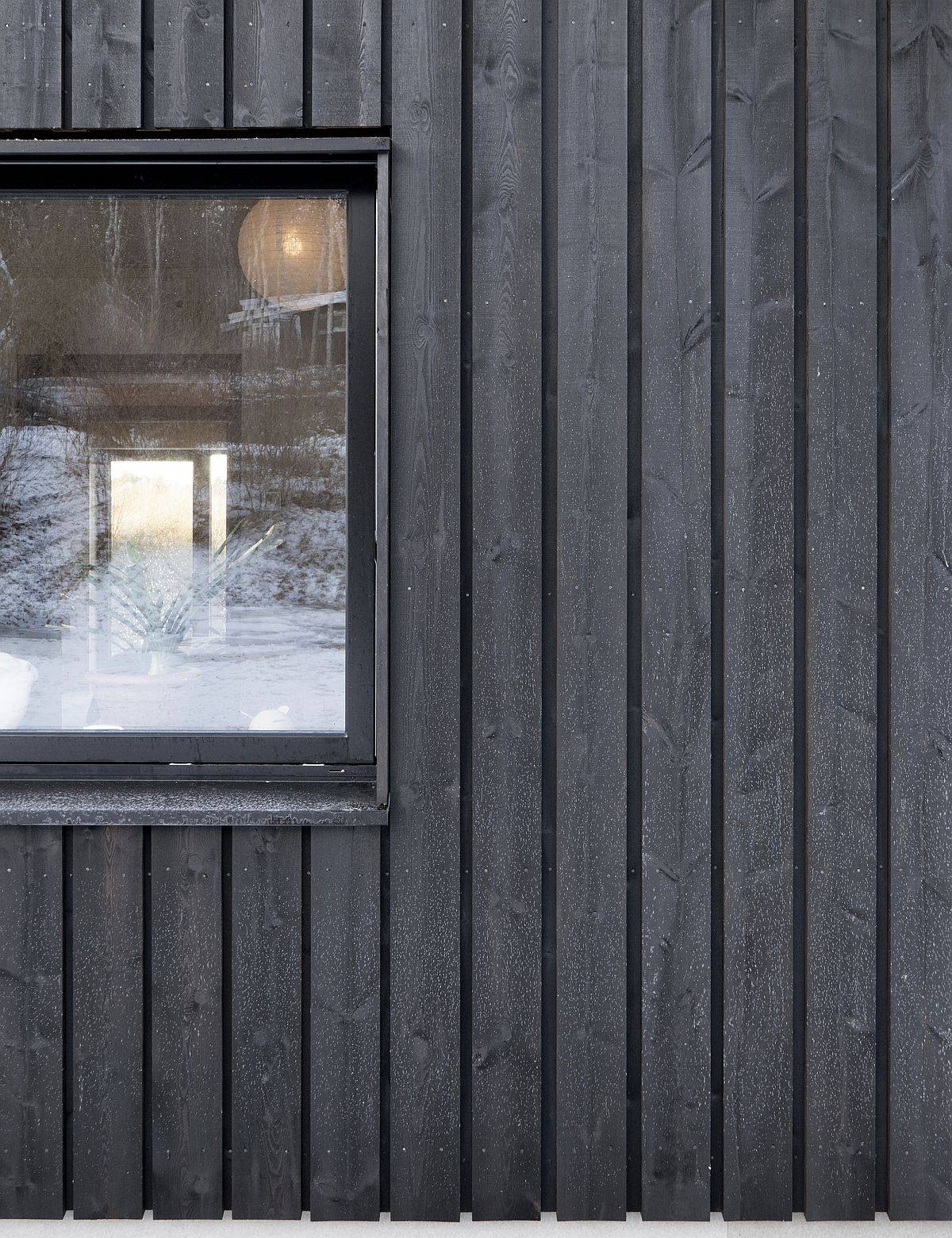 Cross-laminated wood treated with black tar shape the exterior of this countryside Swedish home