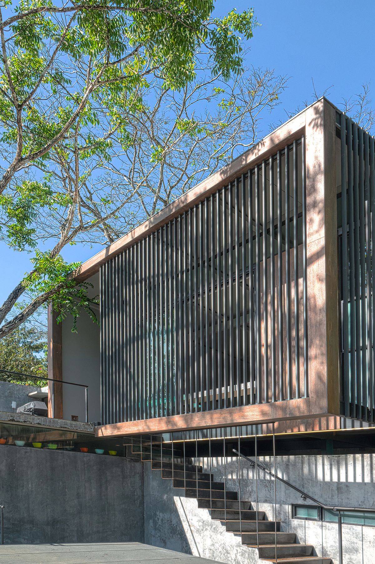 Custom entry of the home combines concrete with a hint of wood and metal