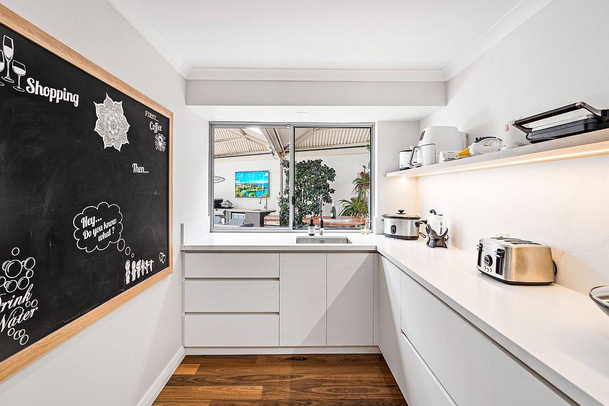 Floating shelf and window occupy space that would have been otherwise taken up by upper cabinets