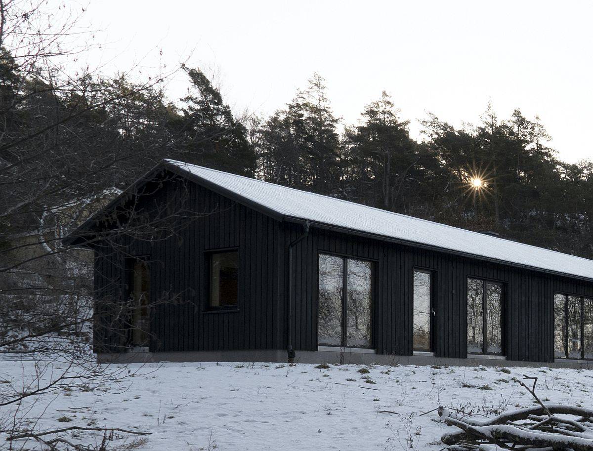 Modern rustic family house in Sweden with black tar treated woodsy exterior