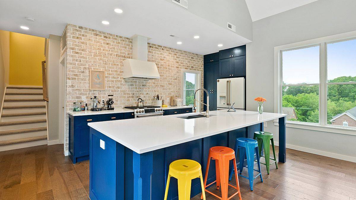 Smart, modern kitchen with brick wall backsplash and ample natural light