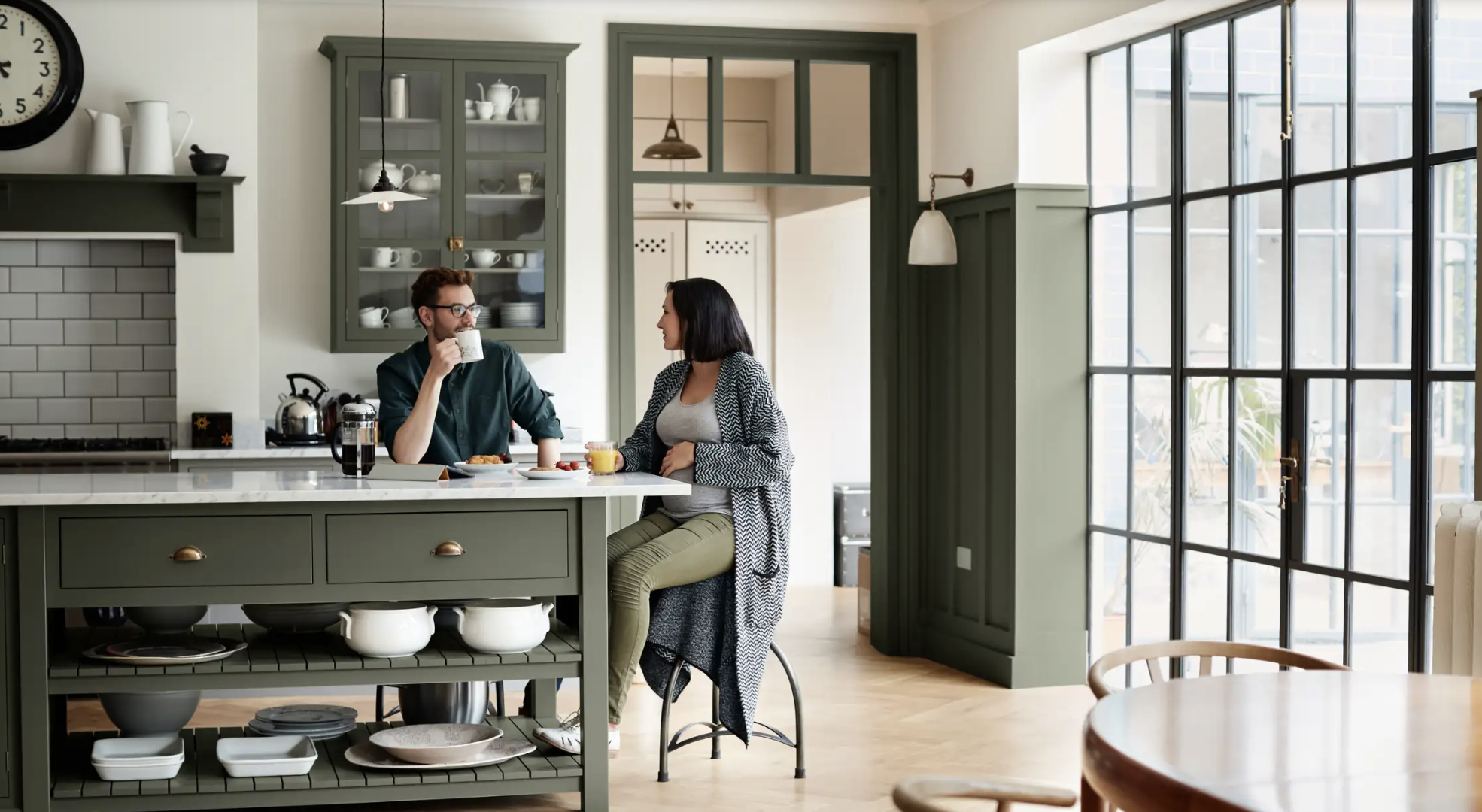 green kitchen man and woman sitting island