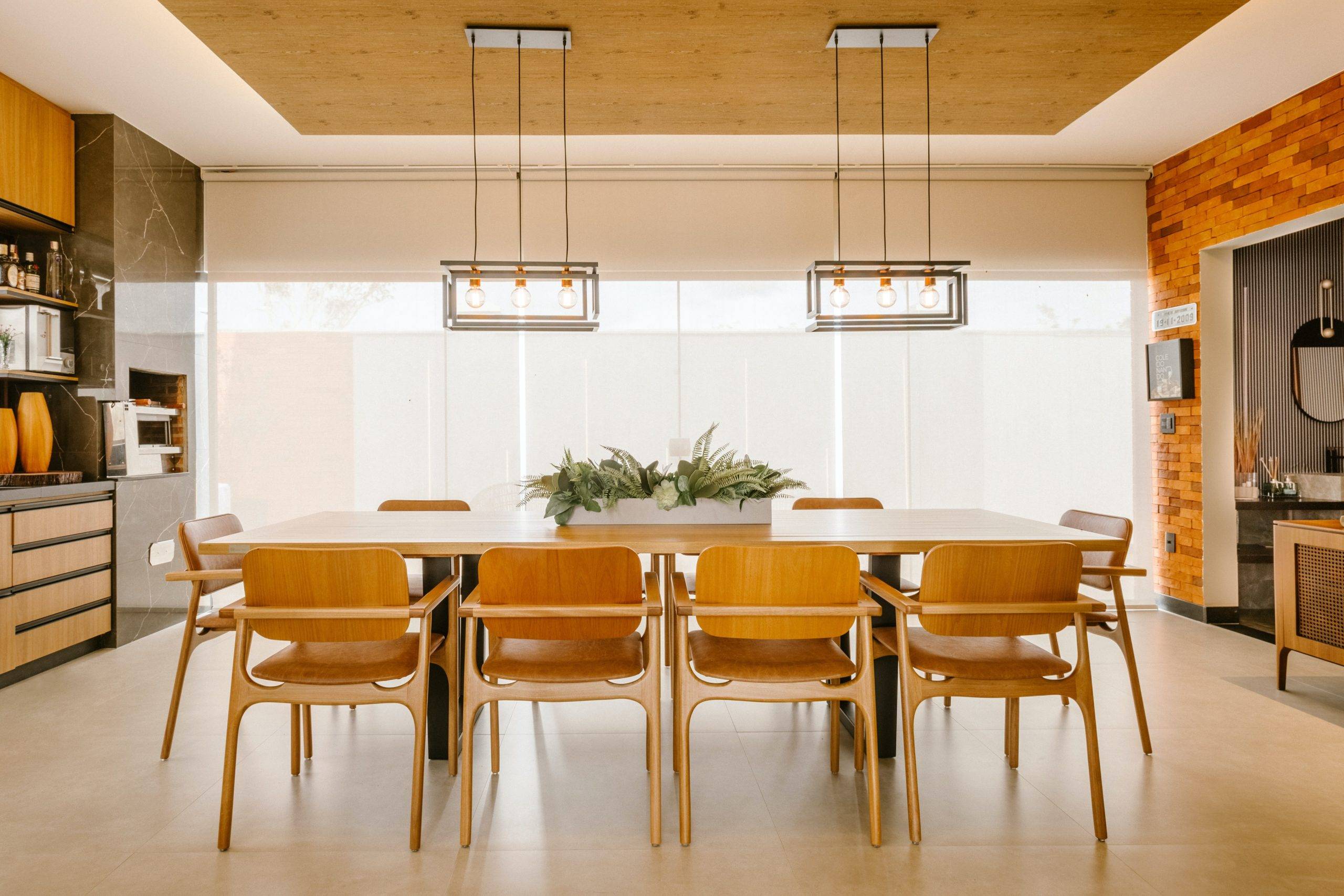 dining room with teak table and two hanging chandeliers