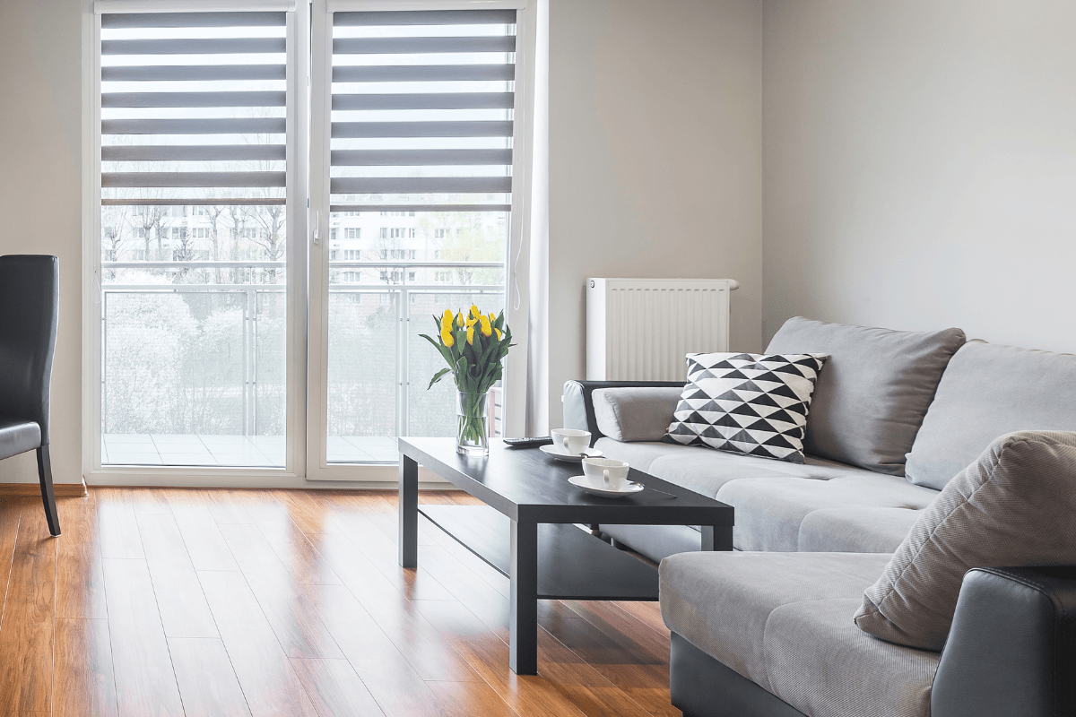 clean living room grey couch doors with blinds