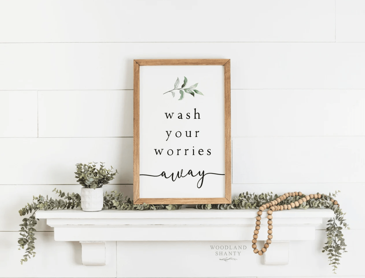 wash your worries away rustic light wood sign on shiplap white background with greenery garland and wood beads hanging shelf farmhouse