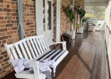 hanging white porch swing brick porch white shutters wood plank floor outside