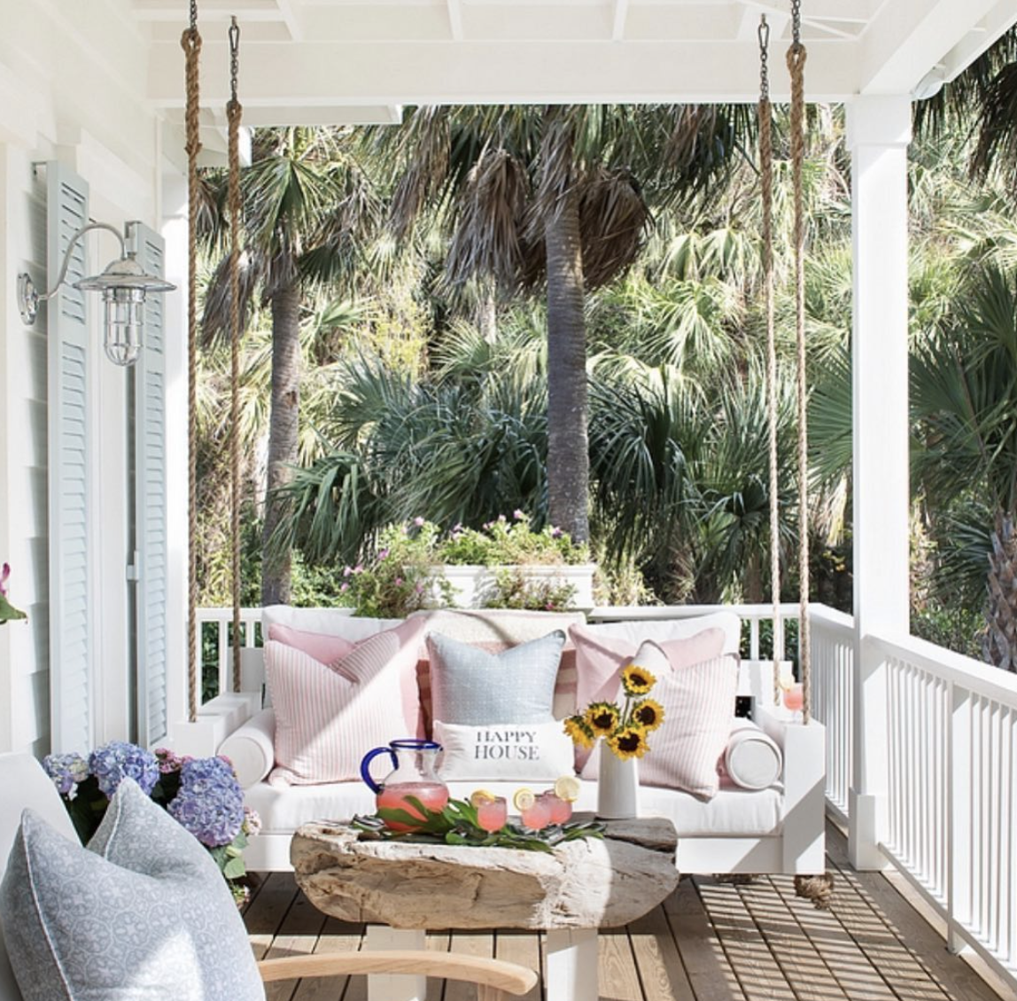 low hanging porch swing white cushions large pillows rope blue shutters white porch rustic driftwood coffee table