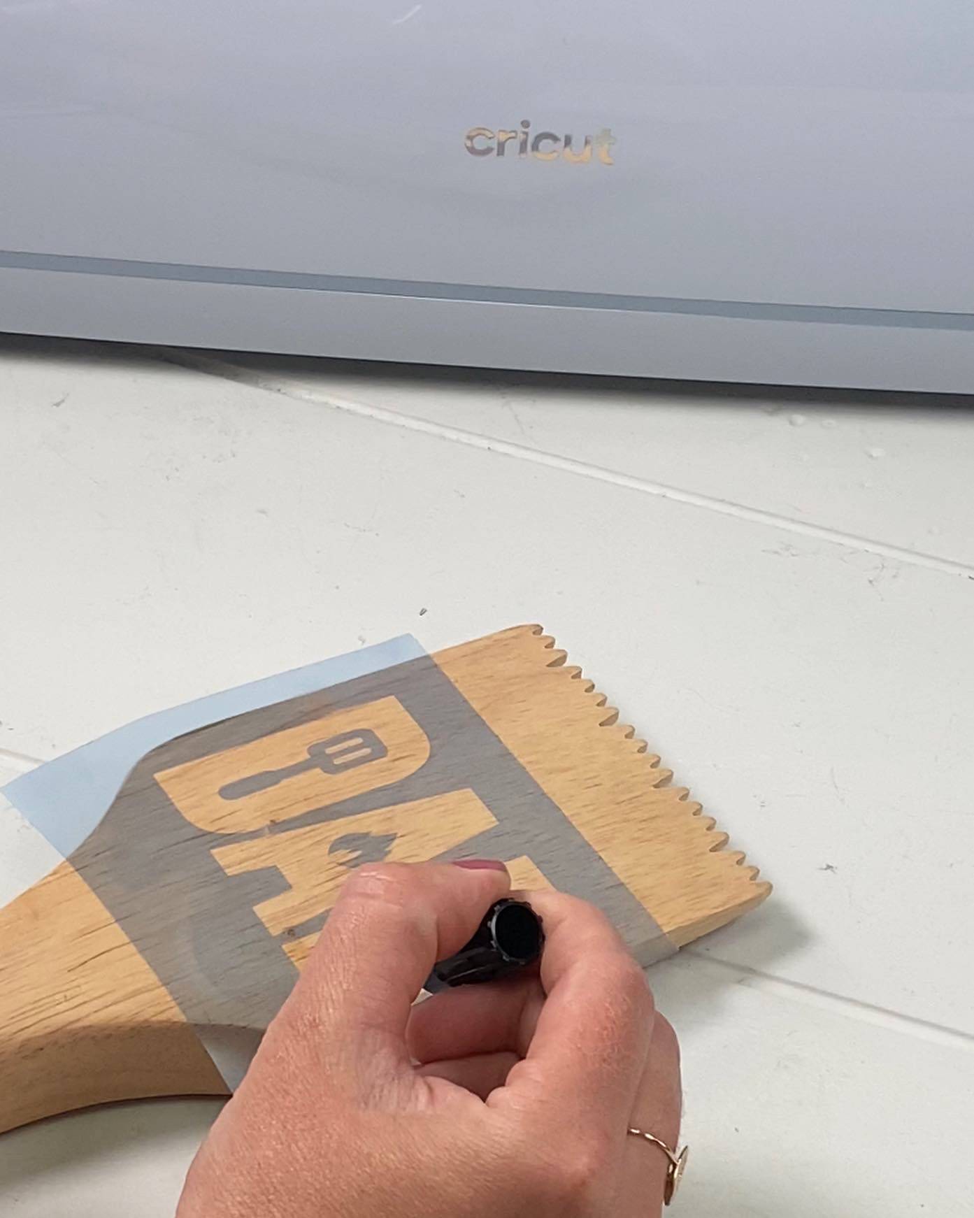 hand marking on wooden bbq scraper dad stencil white background cricut
