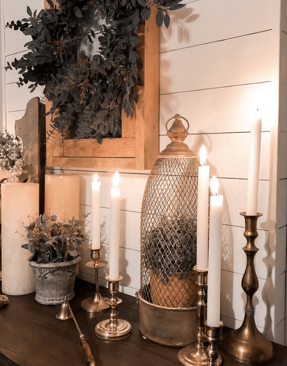 brass candlesticks on dresser with cage topiary greenery