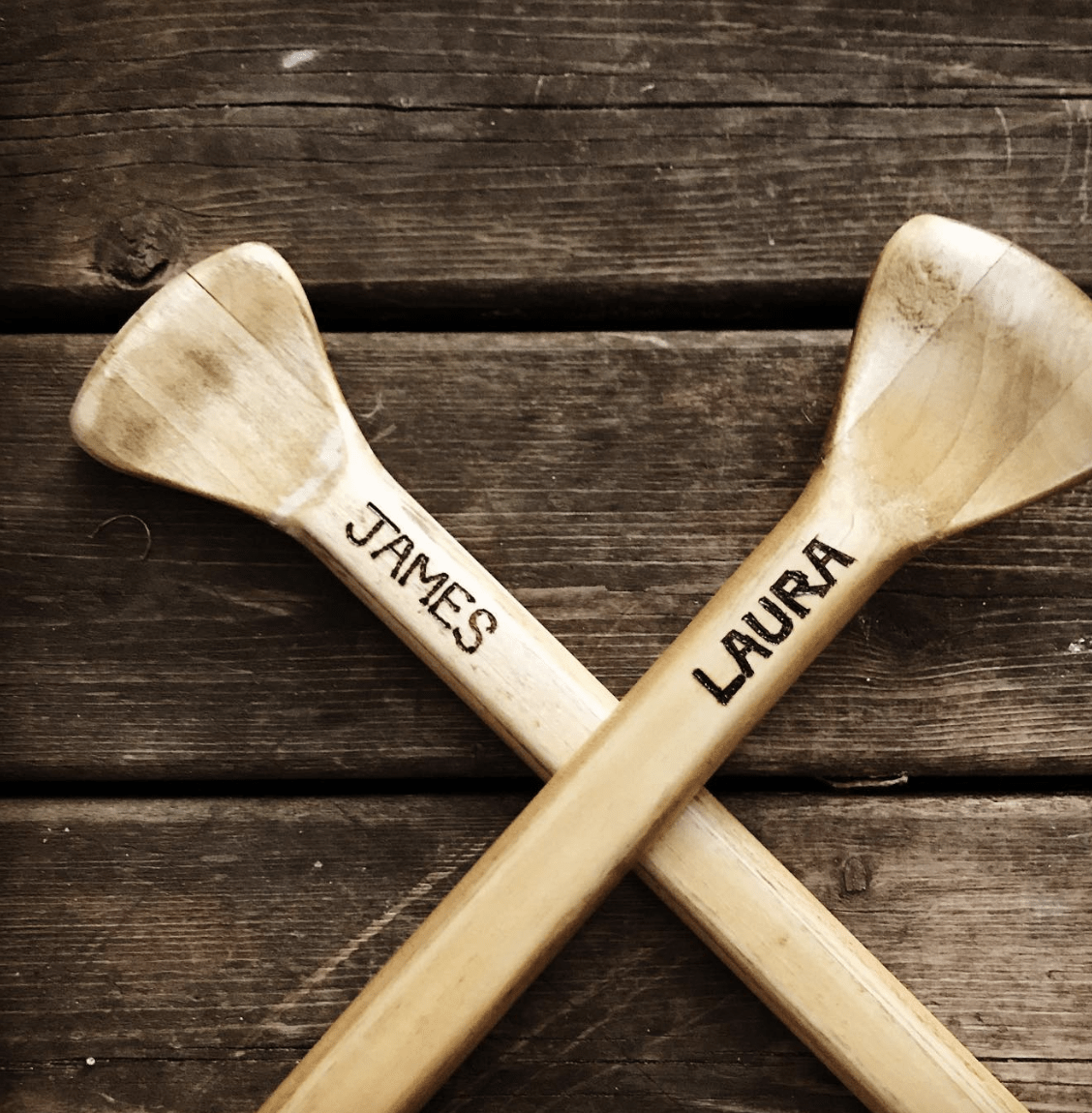 canoe paddles with wood burnt names on wood background