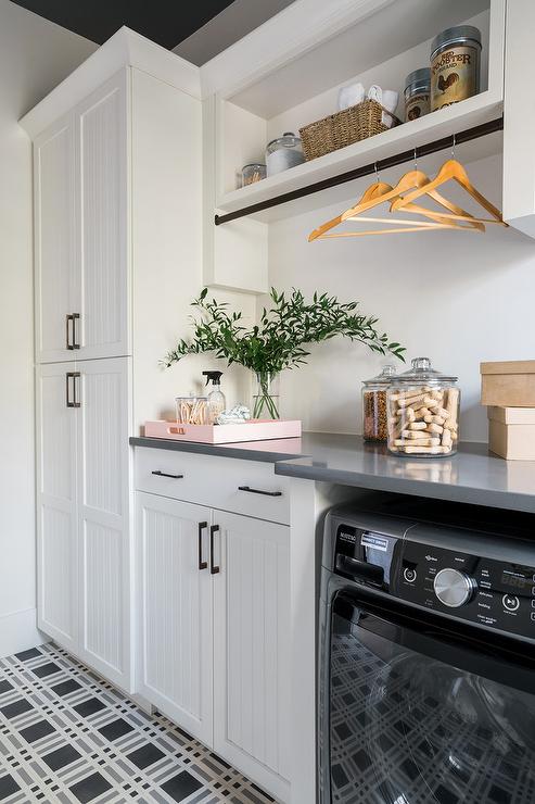 black white checker floor tiles clothing rod mounted under shelf wood hangers white shaker cabinetry