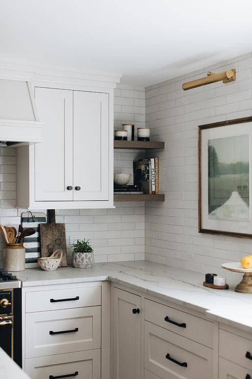 white cabinetry corner shelves open kitchen wall art marble countertops