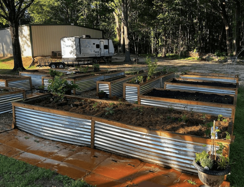 corrugated metal wood frame garden beds raised wide angle shot trailer in background