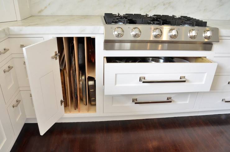 dividers inside cupboard pans cutting boards white cabinetry stove