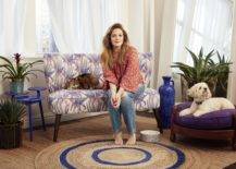 Drew barrymore sitting on a flower sofa with a cat and dog