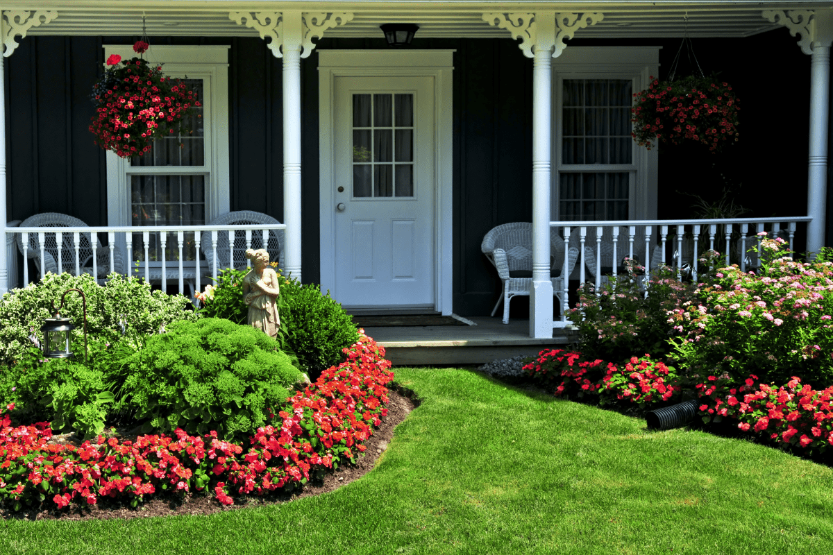 front yard door close up dark blue house flower beds green grass