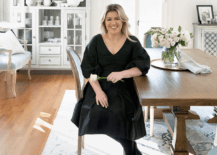 kelly clarkson sitting at a table in a large decorated room