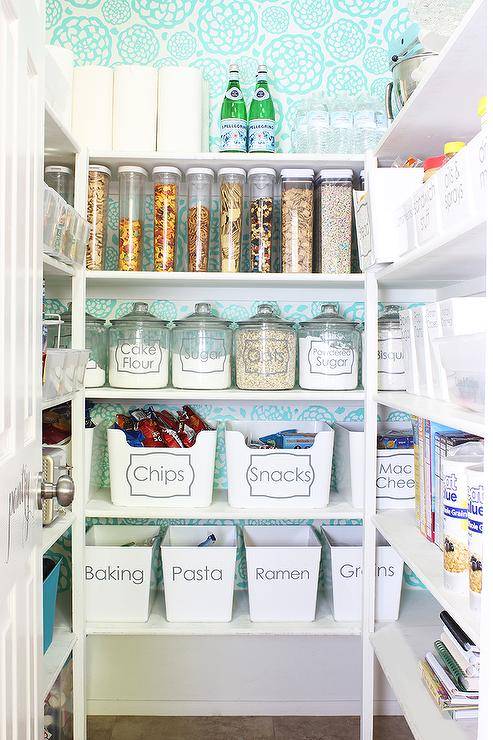 labeled bins and glass jars in pantry blue patterned wallpaper background