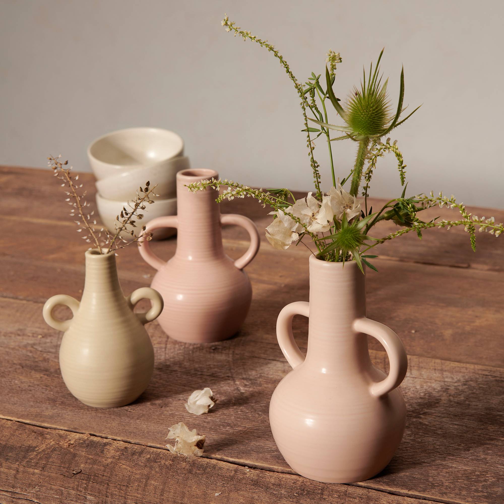 pale pink blush and neutral vases on a wood top table with florals and greenery