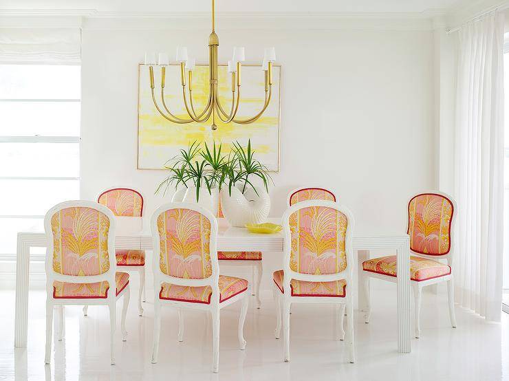 white pink and orange dining chairs gold chandelier yellow wall art