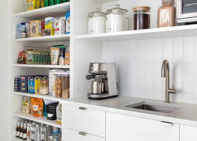 organized pantry lined up products sink coffee maker open shelving