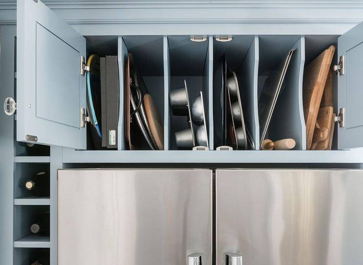 over the fridge divider storage blue cabinetry close up stainless steel
