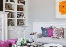 Living room coffee table bookshelf purple accent pillow orange wallart