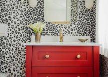 red washstand with white sink black spot background wallpaper mirror and wall sconces bathroom
