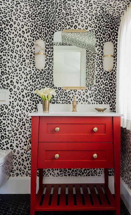 red washstand with white sink black spot background wallpaper mirror and wall sconces bathroom 