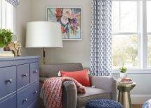 red and blue bedroom with sitting chair throw ottoman lamp with white shade dresser large window with curtains